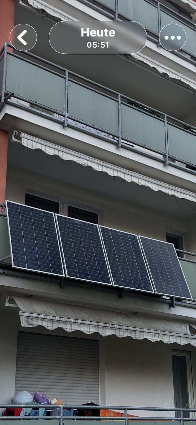Balkon eines Wohnhauses mit Solarmodulen am Geländer